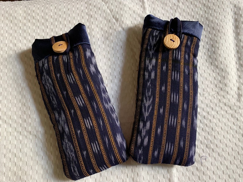 May include: Two blue and white striped fabric pouches with wooden buttons. The pouches have a drawstring closure.