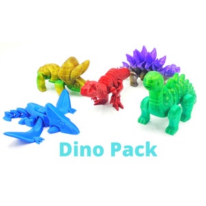 May include: A set of five colorful dinosaur figurines, including a red, green, blue, purple, and gold dinosaur. The dinosaurs are all in different poses and have a variety of textures. The set is labeled "Dino Pack".