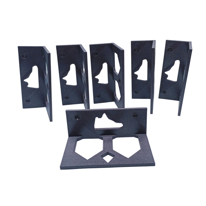 May include: Six black plastic shoe display stands with a shoe cutout. The stands are designed to hold sneakers.