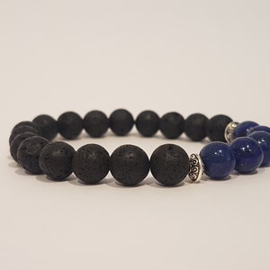 May include: A black lava rock and blue lapis lazuli beaded bracelet with a silver spacer bead.