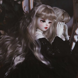 May include: A doll with long, wavy, silver hair wearing a black lace dress and looking into a mirror with an ornate frame.