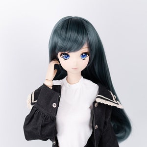 May include: A doll with long, dark green hair, blue eyes, and a white shirt. She is wearing a black denim jacket with a white lace collar and black denim pants.