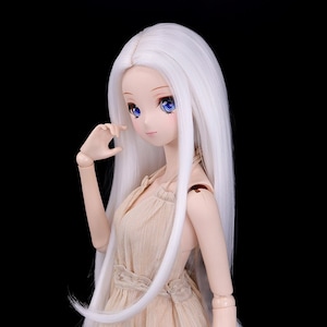 May include: A white doll with long, straight, white hair wearing a beige dress with a lace trim.