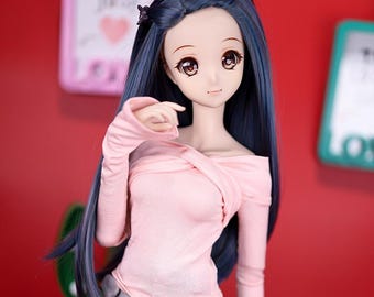 Puede incluir: Una muñeca con pelo largo azul, que lleva un top rosa con los hombros descubiertos y una falda vaquera gris con aberturas laterales. La muñeca tiene ojos grandes y está adornada con pequeñas pinzas para el pelo. El fondo es rojo.