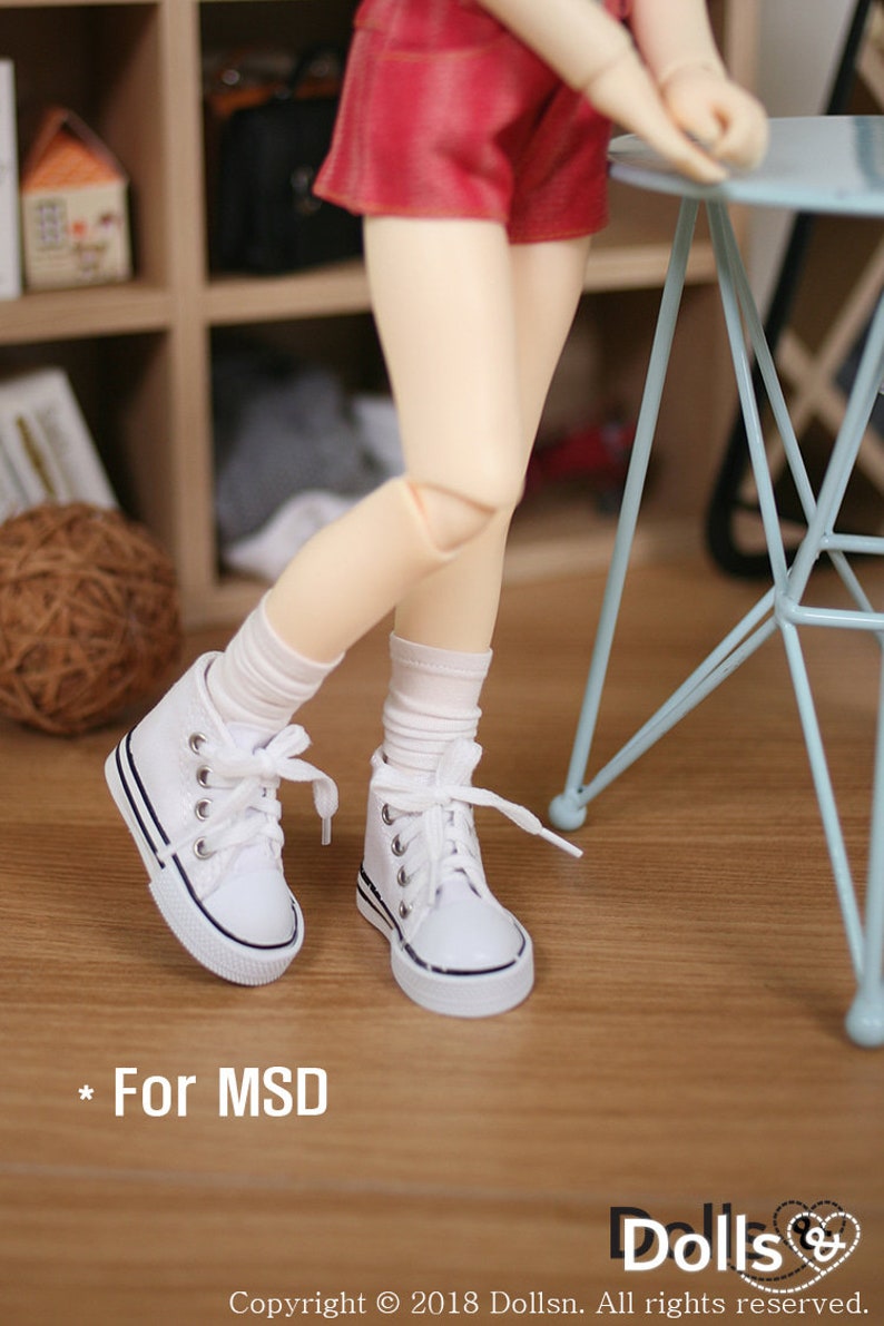 May include: White canvas high-top sneakers with black laces and a black trim around the sole. The sneakers are worn by a doll with white socks and a red skirt. The text "* For MSD" is visible in the lower left corner of the image.
