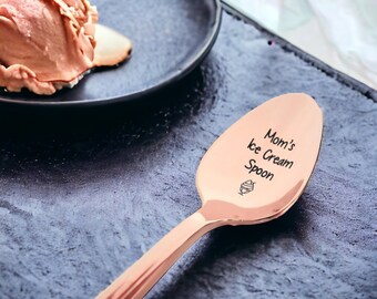 May include: A rose gold ice cream spoon with the text "Mom's Ice Cream Spoon" engraved on the front. A small ice cream cone icon is also engraved on the spoon.
