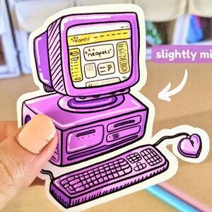 May include: A purple and yellow computer sticker featuring a cartoon image of a computer with the Neopets website open on the screen. The computer has a keyboard and a heart-shaped mouse. The sticker is slightly miscut.