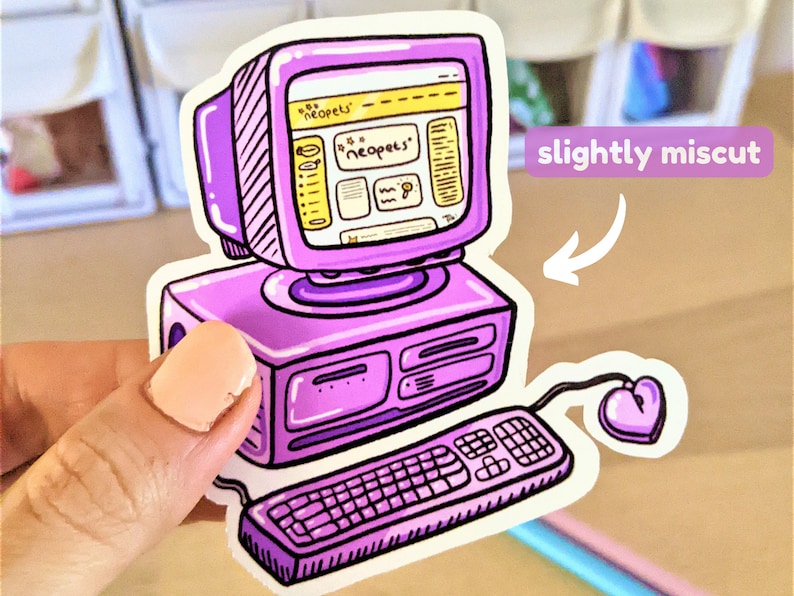 May include: A purple and yellow computer sticker featuring a cartoon image of a computer with the Neopets website open on the screen. The computer has a keyboard and a heart-shaped mouse. The sticker is slightly miscut.