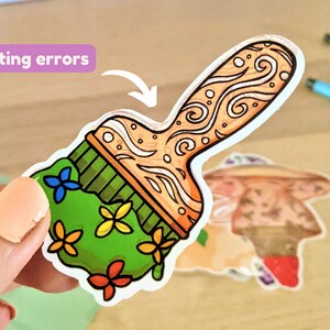 May include: A green paintbrush sticker with a floral design and a brown handle with a swirl pattern. The sticker has the words "printing errors" written on it.