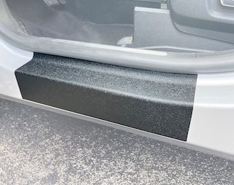 Könnte beinhalten: Ein schwarzer, strukturierter Schwellerschutz für Autotüren ist an einer silbernen Autotür angebracht. Der Schutz ist so konzipiert, dass er Kratzer und Abrieb verhindert.
