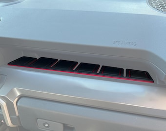 May include: Black dashboard organizer with red trim and six compartments. The text "SRS AIRBAG" is visible on the dashboard.
