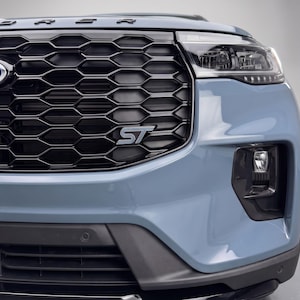 Könnte beinhalten: Die Frontpartie eines hellblauen SUV mit einem glänzend schwarzen Wabengrill und einem silbernen ST-Emblem. Das Fahrzeug verfügt über eine scharfe LED-Scheinwerfereinheit, ein schwarzes Nebelscheinwerfergehäuse und eine schwarze untere Stoßstangenverkleidung.