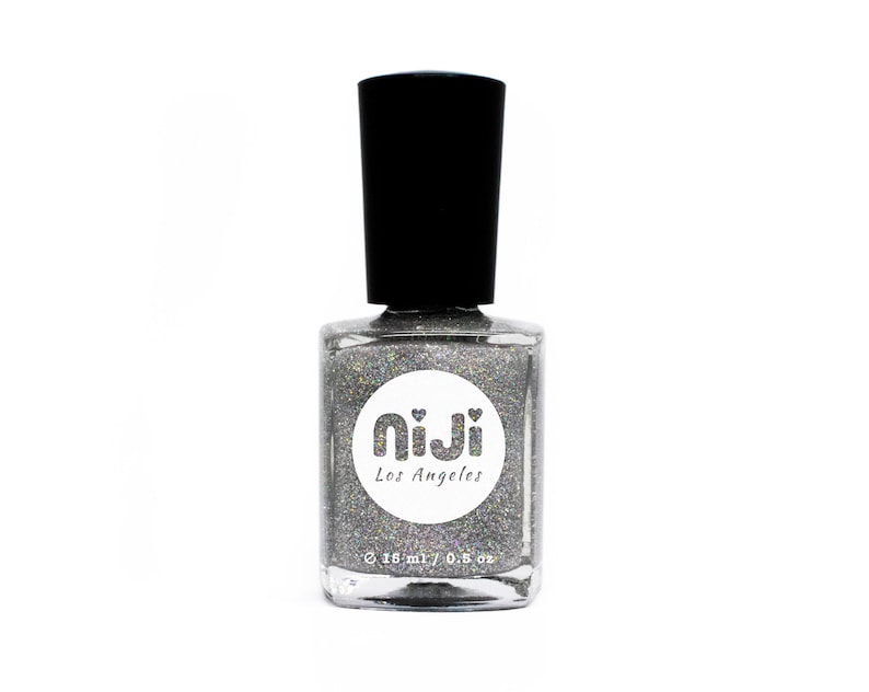 May include: A silver glitter nail polish bottle with a white circle label that says "NiiJi Los Angeles" and a black cap.
