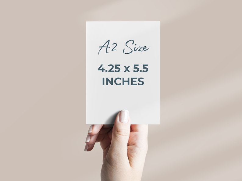 May include: A white card with the text "A2 Size 4.25 x 5.5 INCHES" written in black. A hand is holding the card.