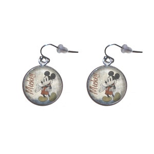 May include: A pair of silver dangle earrings with round, silver-rimmed charms featuring a vintage image of Mickey Mouse with the word "Mickey" printed on the charm.