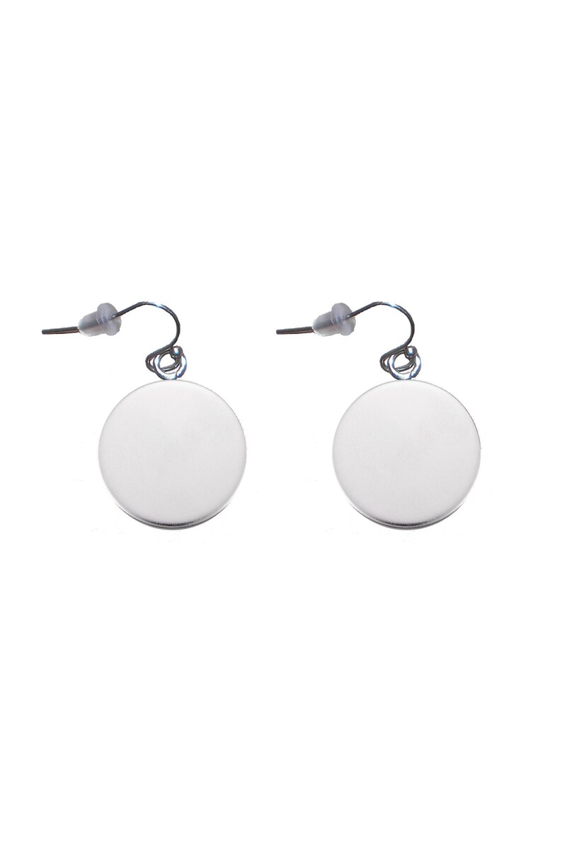 May include: A pair of silver dangle earrings with round, smooth, silver discs. The earrings have a simple, minimalist design.