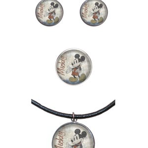 May include: A set of Mickey Mouse jewelry featuring a necklace, earrings, and a brooch. The necklace has a black leather cord and a round pendant with a vintage image of Mickey Mouse. The earrings are silver with round pendants featuring a vintage image of Mickey Mouse. The brooch is a round silver pin with a vintage image of Mickey Mouse.