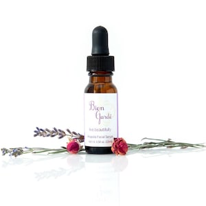 May include: A brown glass bottle with a dropper top, labeled "Bien Gardé" and "live beautifully  -  Rosehips Facial Serum -  net wt 0.50 oz (15ml)". The bottle is surrounded by dried lavender and rose buds.