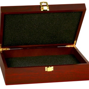 May include: A mahogany wood box with a gold latch and hinges. The box is lined with black foam.