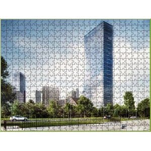 May include: A view of a city skyline with tall buildings and trees in the foreground. The buildings are mostly glass and steel, and the sky is blue with some clouds.