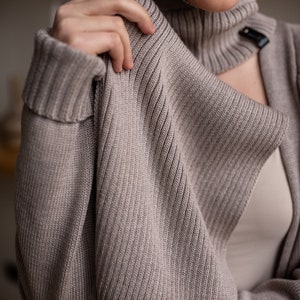 Ligh beige merino wool scarf in a ribbed pattern.