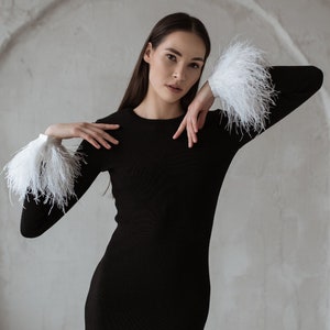 White ostrich feather cuffs on a black merino wool dress