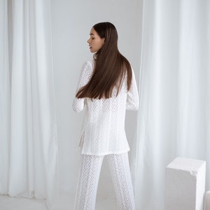 knitted merino wool white lace suit and pants for formal, office or restaurant look. Handmade in Lithuania. A dark hair lady wearing the set.