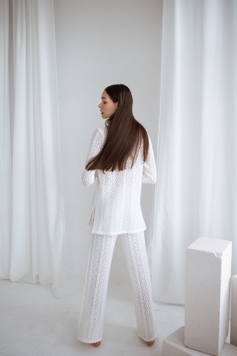 knitted merino wool white lace suit and pants for formal, office or restaurant look. Handmade in Lithuania. A dark hair lady wearing the set.