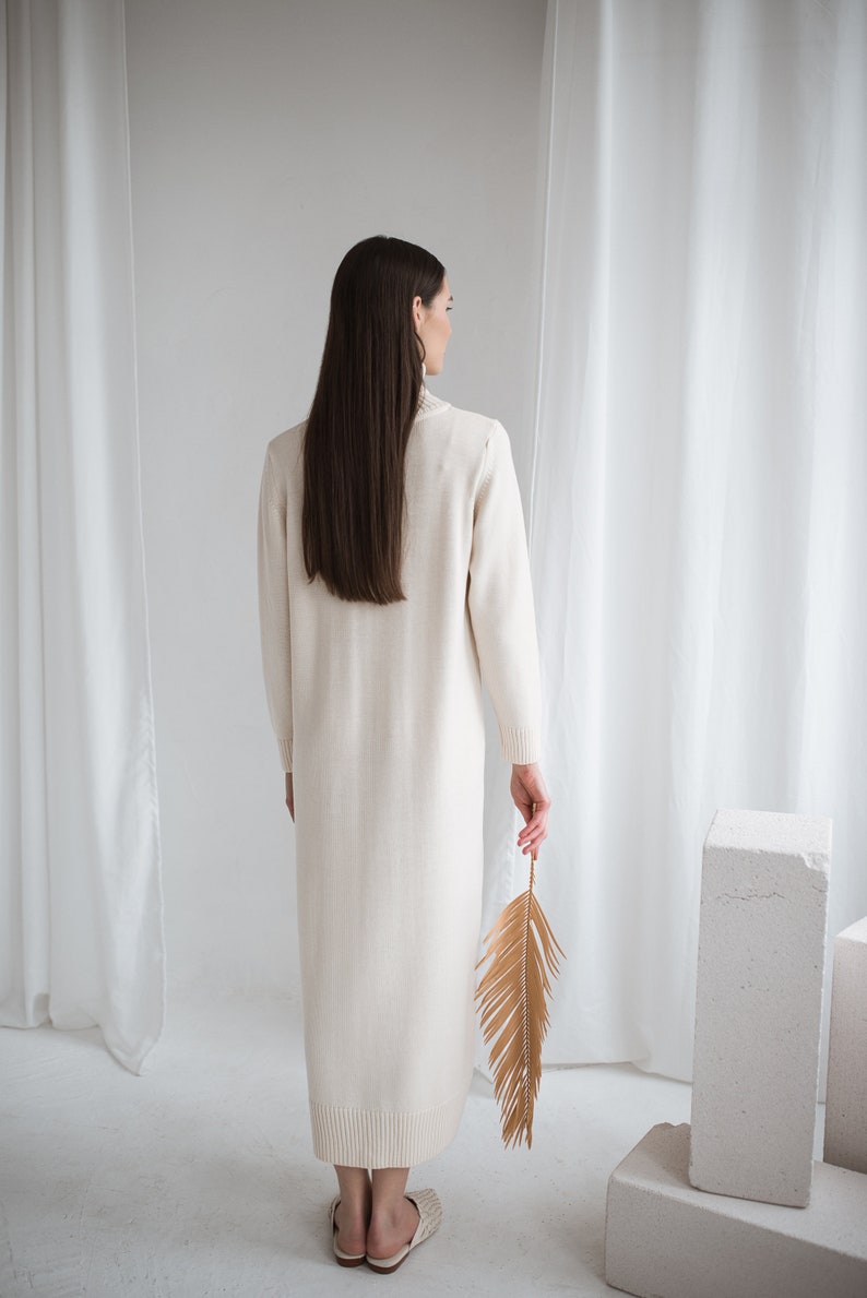 long turtleneck off white color knit merino wool dress. dark haired lady wearing this dress, back look.