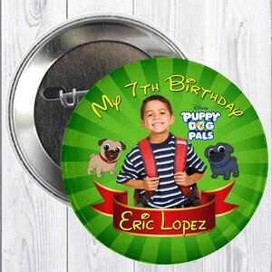 Pode incluir: Um botão de aniversário verde e vermelho com um menino usando uma camisa listrada e uma mochila. O botão diz "Meu 7º aniversário" e apresenta o logotipo do Disney Puppy Dog Pals. O nome do menino é Eric Lopez.