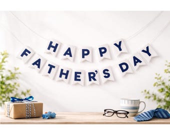 Könnte beinhalten: Ein Banner zum Vatertag mit den Worten "HAPPY FATHER'S DAY" in marineblauen Buchstaben hängt über einem Holztisch. Ein verpacktes Geschenk, eine Tasse, eine Brille und eine Krawatte befinden sich ebenfalls auf dem Tisch, was auf eine Feier hindeutet.