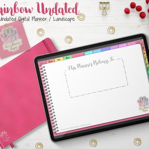 Puede incluir: Un planificador digital rosa con el texto "Rainbow Undated" y "Undated Digital Planner / Landscape". El planificador está abierto en una página que dice "This Planner Belongs To". También se ven un cuaderno rosa y un logotipo de huella de pata.