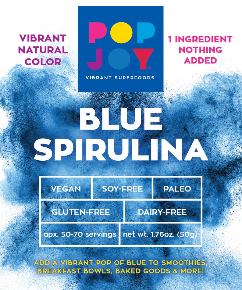 Op de afbeelding: Blauw spirulina poeder in een blauwe en witte zak met de merknaam "Pop Joy" en de tekst "Vibrant Superfoods". De zak vermeldt ook "1 ingredi&euml;nt, niets toegevoegd" en vermeldt het product als veganistisch, soja-vrij, glutenvrij, paleo en zuivelvrij. De zak geeft aan dat het ongeveer 50-70 porties bevat en een nettogewicht heeft van 1,76 ounce (50 gram).