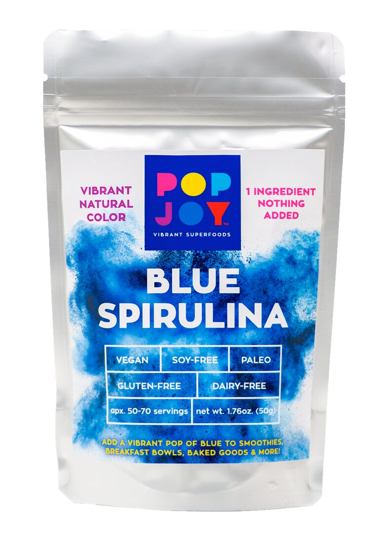 Op de afbeelding: Een zilveren zakje met een blauw en wit etiket waarop staat "Pop Joy Vibrant Superfoods Blue Spirulina 1 Ingredi&euml;nt Niets toegevoegd". Het etiket vermeldt ook dat het product veganistisch, soja-vrij, glutenvrij, paleo en lactosevrij is. Het zakje bevat 50 gram blauw spirulina-poeder, wat ongeveer 50-70 porties is.