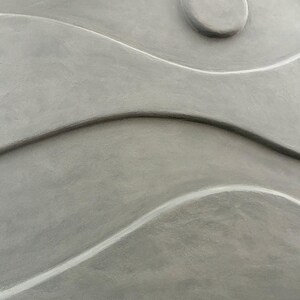 May include: Abstract gray wall art with a textured surface. The design features flowing, wave-like shapes and a circular element, creating a sense of movement and depth. The artwork is a neutral color, suitable for various interior styles.