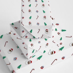 May include: Stack of three white gift boxes with a repeating pattern of a black Santa Claus, candy canes, Christmas trees, and presents. The boxes are wrapped in white paper with a festive Christmas design.