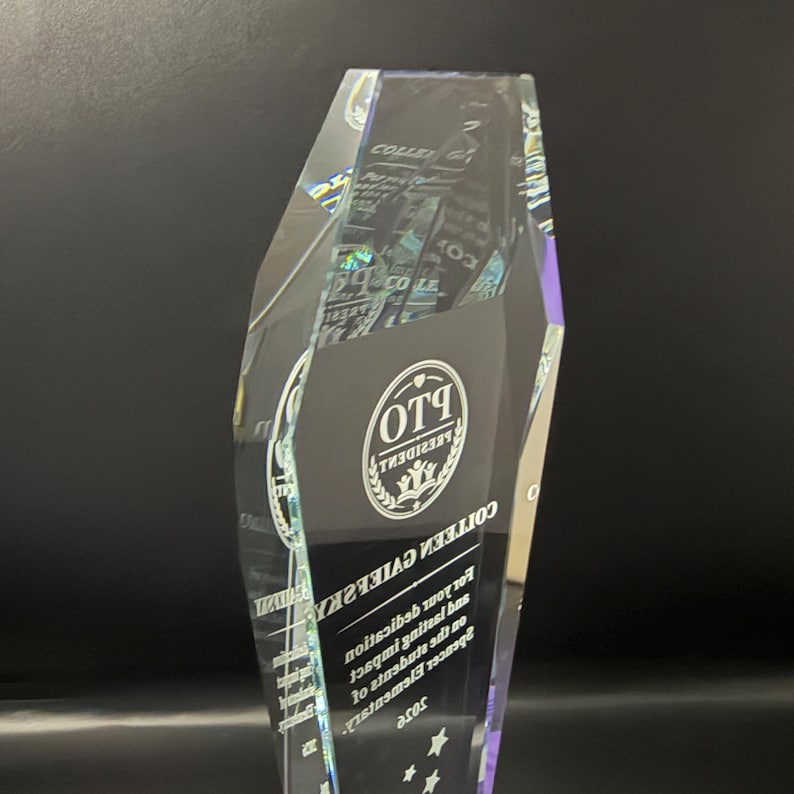 Op de afbeelding: Een heldere, gefacetteerde glazen trofee met een ge&euml;tst cirkelvormig logo met de tekst PTO PRESIDENT. Onder het logo is de naam COLLEEN GAIEFSKY gegraveerd, gevolgd door tekst die de toewijding en impact op Spencer Elementary 2025 erkent.
