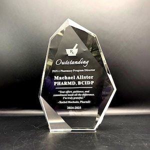 May include: A clear, faceted crystal award with the word "Outstanding" and a mortar and pestle symbol. The award is engraved with a name, title, and a thank you message. The year 2024-2025 is also included.