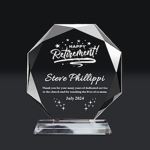 Può includere: Un premio di pensionamento in cristallo trasparente con un design sfaccettato. Il testo recita "Happy Retirement!" sopra il nome "Steve Phillippi" e un messaggio di ringraziamento. È inclusa anche la data "Luglio 2024".