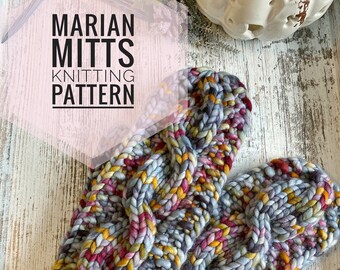 May include: A pair of colorful knitted mittens with a cable knit pattern. The mittens are made with a chunky yarn in shades of gray, yellow, red, and pink. The mittens have a leather tag that says "Peapod".