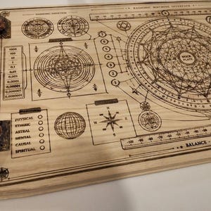May include: A wooden board with intricate etched designs, including geometric shapes, circles, and text. The board features a compass rose, a globe, and a scale. Two corners have embedded crystals. The text includes "Harmonic Induction" and "Balance - Harmony - Res".