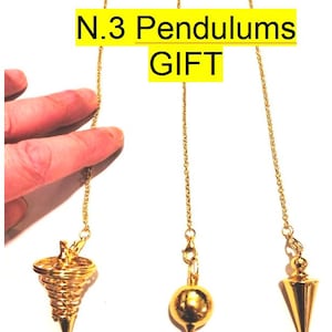 May include: Three gold-colored pendulums with different tip designs hanging from delicate chains. The image includes the text "N.3 Pendulums GIFT" in a yellow box. The pendulums are displayed against a white background.