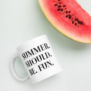 May include: White ceramic mug with black text that reads "Summer. Should. Be. Fun." A slice of watermelon is in the background.