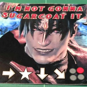 Puede incluir: Una pegatina con un personaje de pelo negro y ojos rojos, con el texto "I'M NOT GONNA SUGARCOAT IT." Debajo, flechas direccionales, una estrella y botones, probablemente para un videojuego.