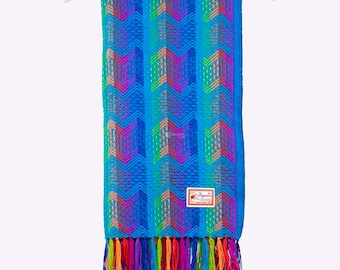 May include: A blue alpaca wool scarf with a colorful geometric pattern and fringe. The scarf has a small tag that says "Espinoza Alpaca".