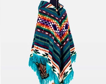 May include: A turquoise, blue, red, orange, and white patterned poncho with a hood and fringe. The poncho is displayed on a wooden mannequin.