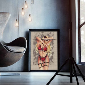 Peut inclure: Une œuvre d'art au point de croix encadrée représente une femme en lingerie rouge avec des lanières noires et des lunettes de soleil. L'œuvre est exposée dans un intérieur moderne avec un mur gris, une chaise design et des ampoules suspendues.