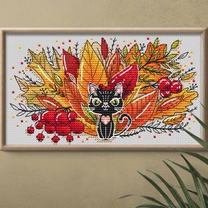 May include: Cross-stitch pattern of a black cat sitting in a pile of colorful autumn leaves. The leaves are red, orange, and yellow. There are also some red berries in the design.
