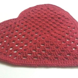 以下が含まれることがあります： 赤いハート型のクロシェ編みラグ。ラグはシンプルなステッチパターンで作られており、わずかにテクスチャのある表面をしています。