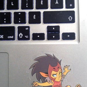 May include: A sticker of a cartoon character with red, yellow, and black hair, wearing a red and yellow outfit, with a red and white belt, and a red and white headband. The character is in a fighting pose with one leg raised and one arm extended.